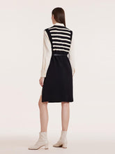 A lady wears a black and white striped shift dress.